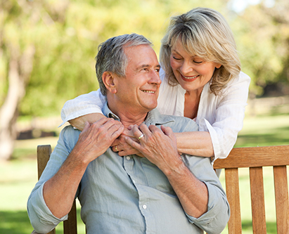 Woman hugging man sitting on a bench