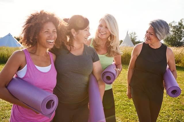 group of women with yoga mats smiling